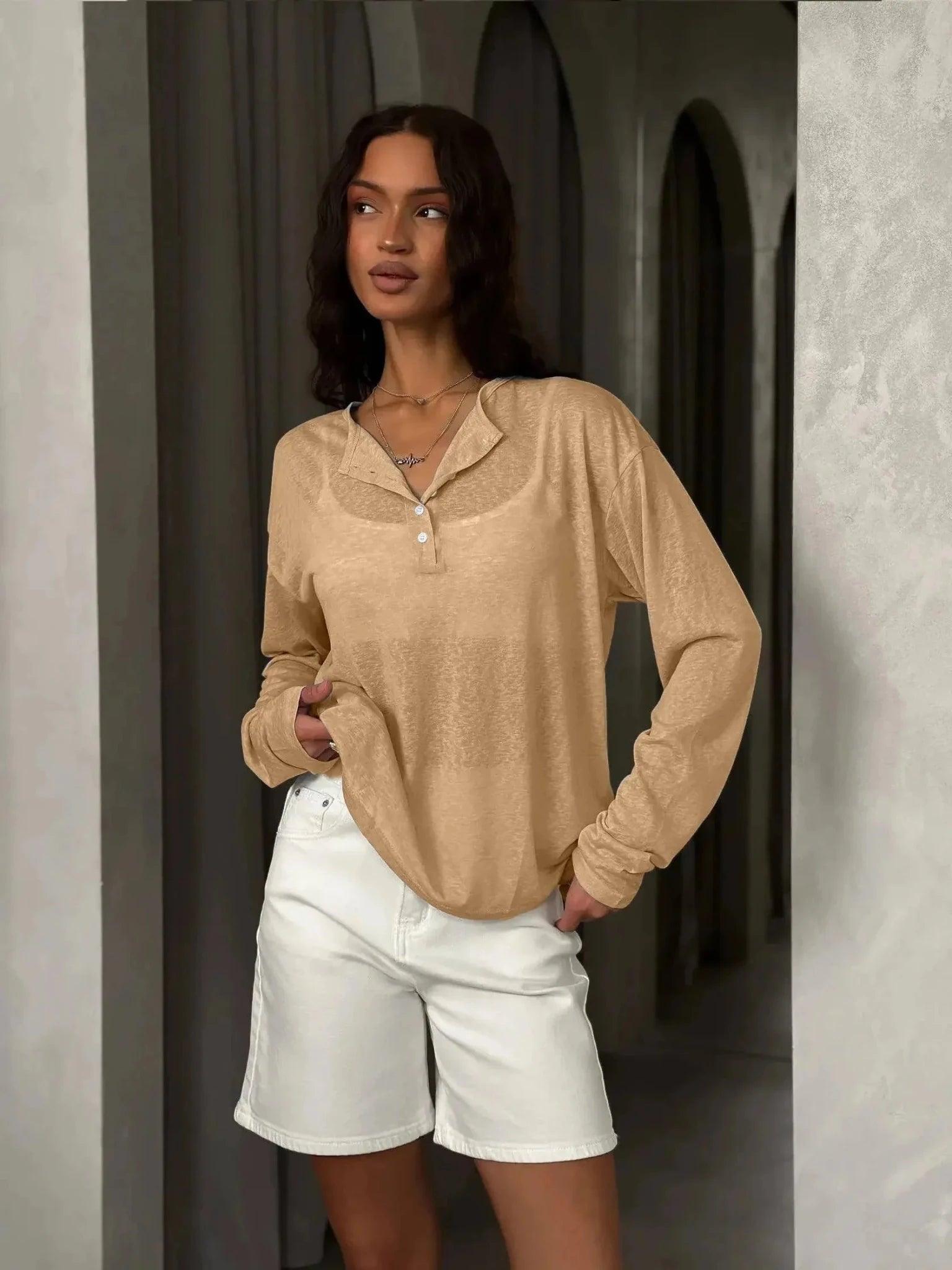 Woman in beige long sleeve button-up top and white denim shorts, stylish casual fashion outfit