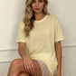 Woman in pale yellow oversized tee with lace trim, casual fashion style