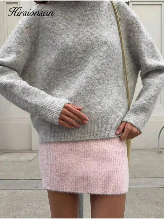 Woman wearing cozy gray sweater and pink knit mini skirt, stylish fall outfit