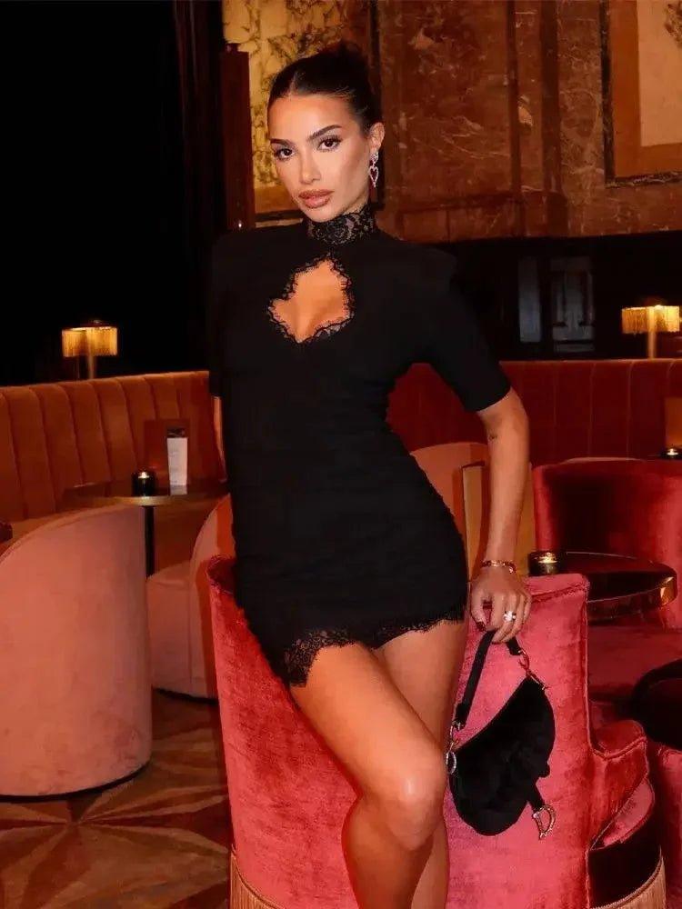 Woman in black lace dress posing on red velvet chair, elegant evening fashion