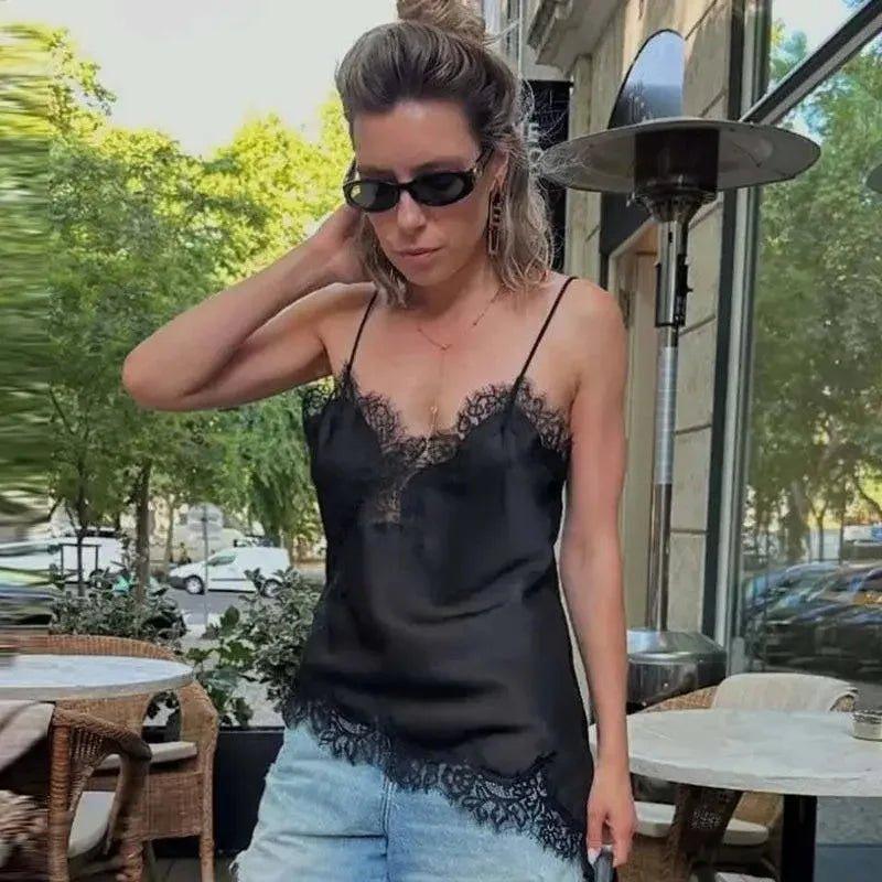 Woman in black lace camisole top and denim shorts, stylish outdoor fashion look