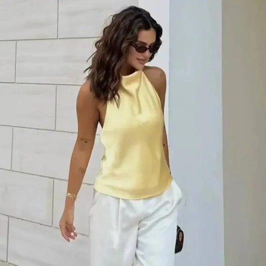 Woman in yellow halter top and white pants, stylish summer fashion outfit