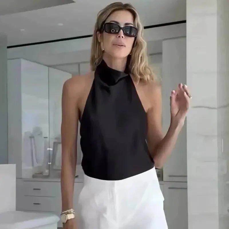 Woman in black halter neck top and white pants, stylish fashion outfit