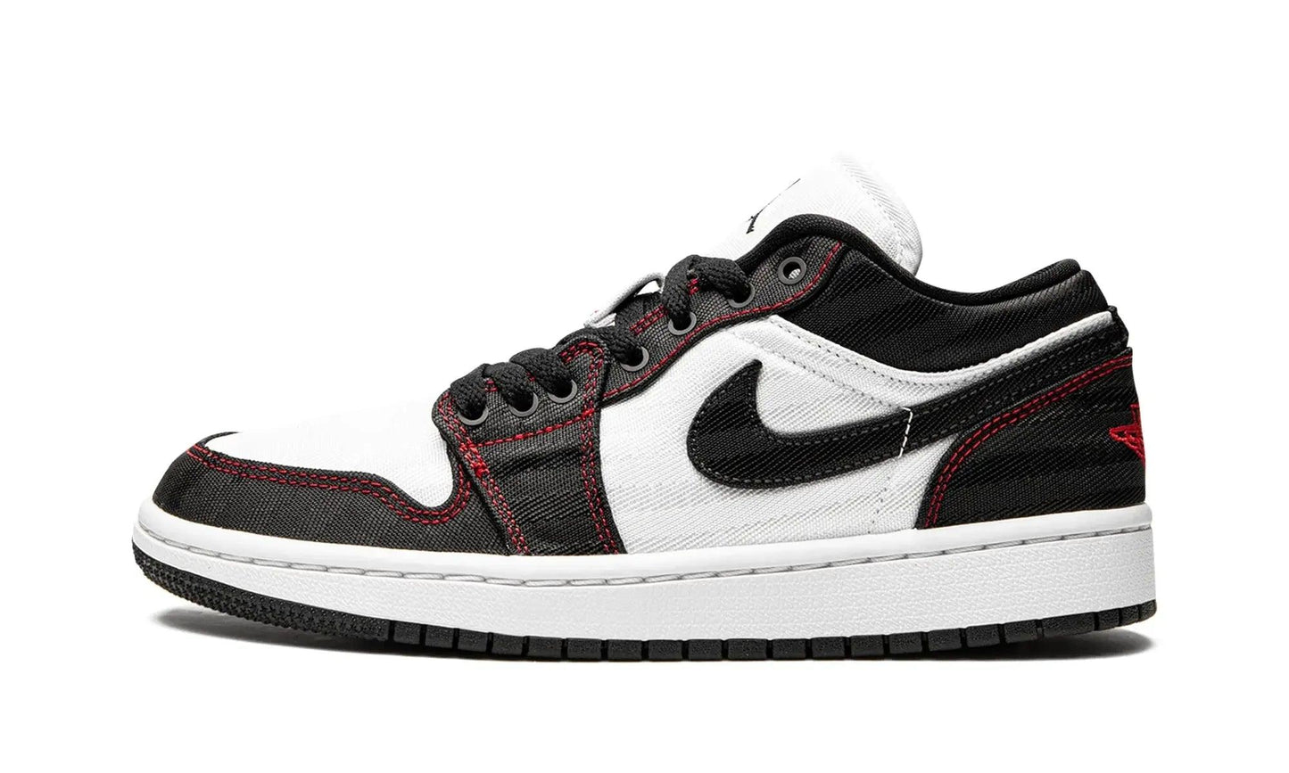 Black and white low-top sneaker with red stitching, Nike swoosh, and canvas texture for women's fashion