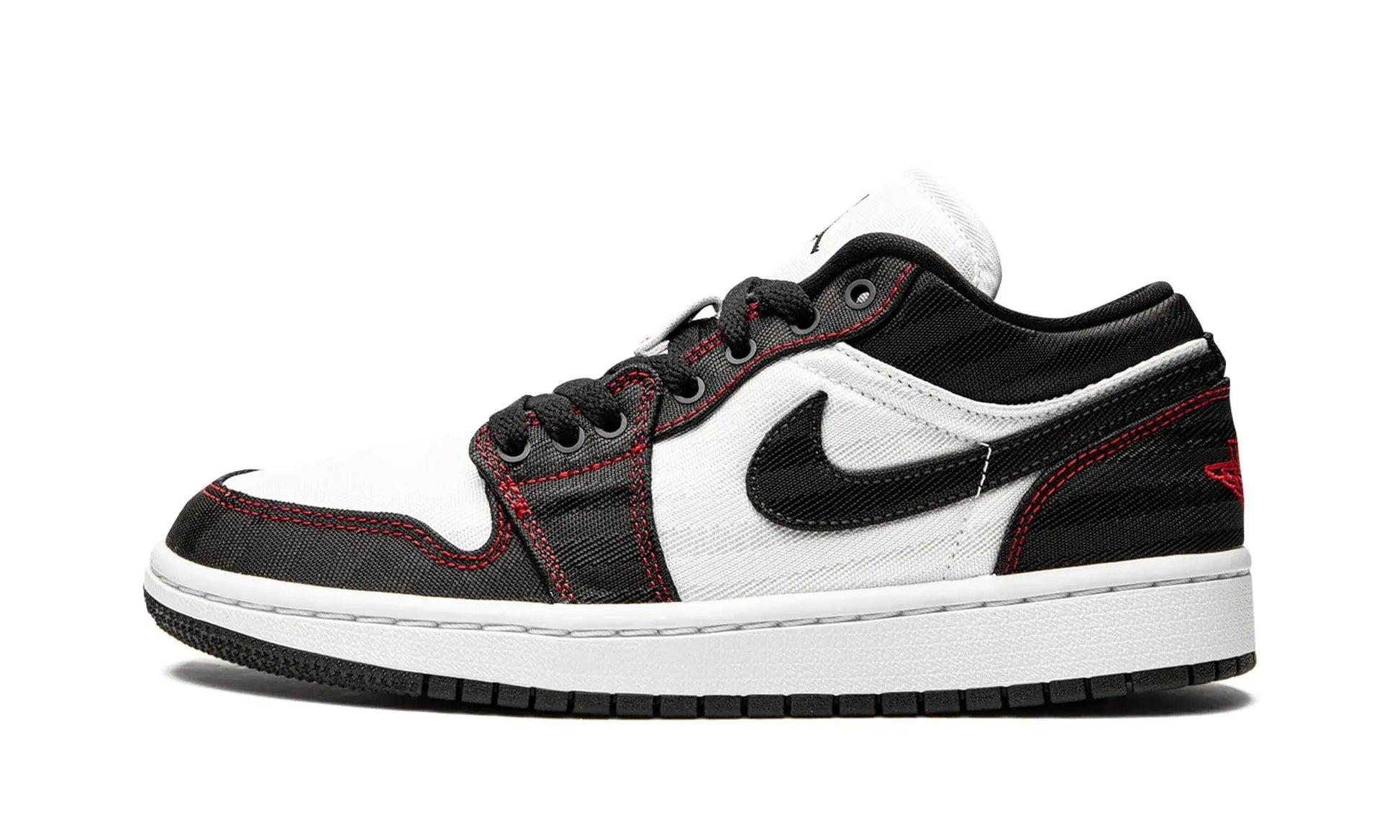 Black and white low-top sneaker with red stitching, Nike swoosh, and canvas texture for women's fashion