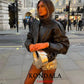 Woman in black leather jacket and gold sequin skirt, stylish street fashion