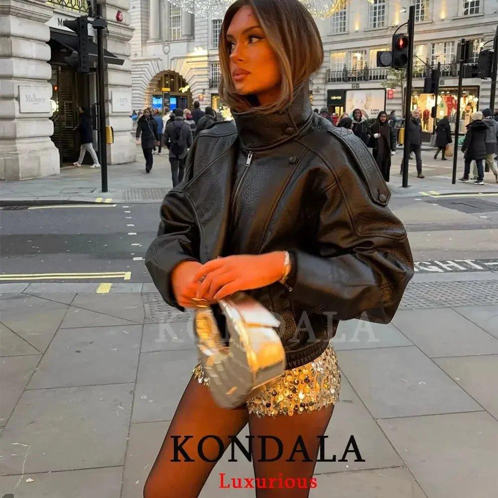 Woman in black leather jacket and gold sequin skirt, stylish street fashion