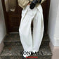 White wide-leg pants with pleats, paired with black gloves and heels, stylish women’s fashion