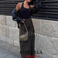 Woman in black tank top, olive pants, and stylish shoulder bag, urban fashion look