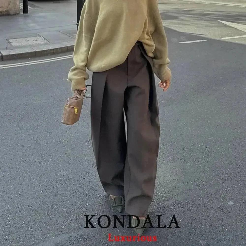 Woman in beige sweater and wide-leg brown pants, street style fashion