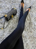 Black tights with pointed-toe flats and patterned handbag on fluffy rug, women's fashion
