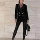 Woman in black velvet blazer with gold buttons, matching pants, heels, and chain bag — chic fashion outfit