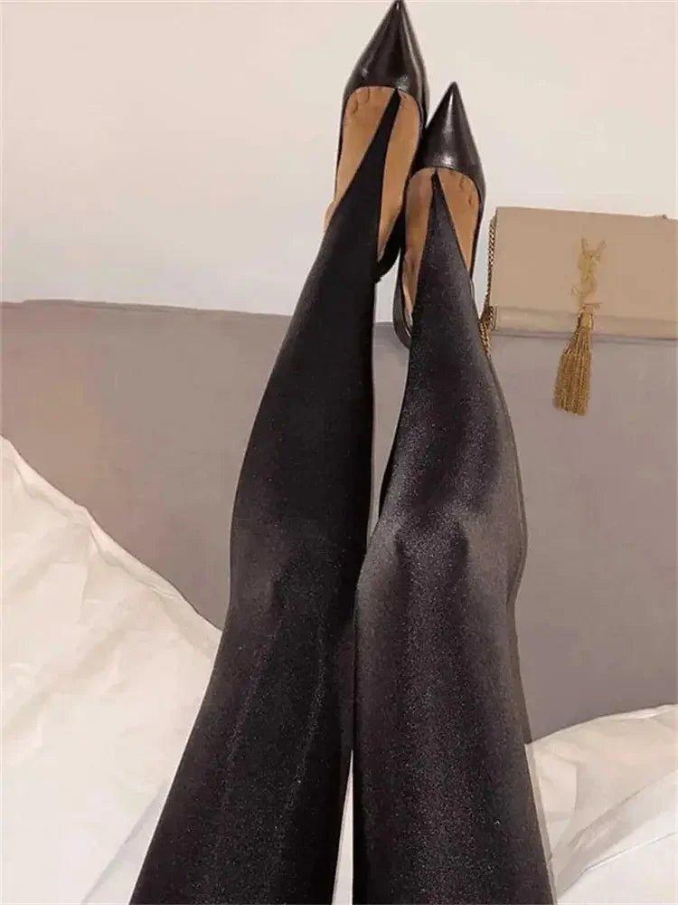 Black high heel pumps with pointed toes, paired with sleek black tights, stylish women's fashion footwear