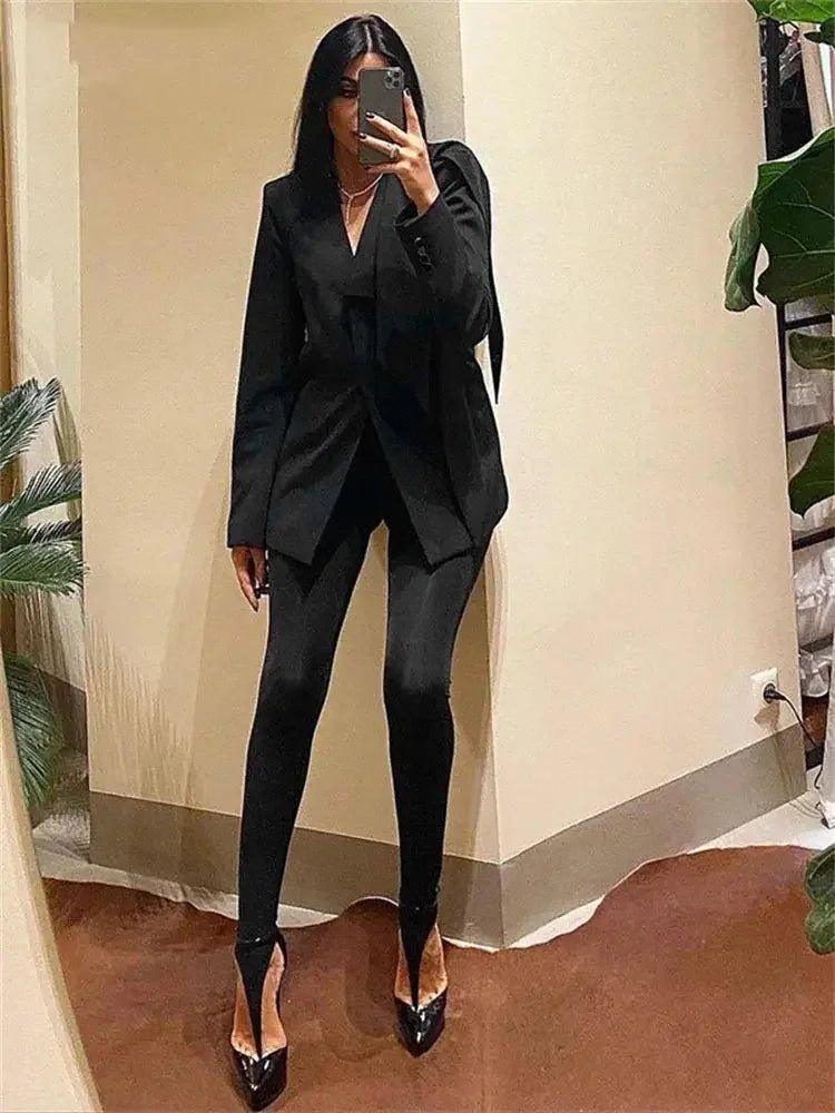 Woman in black blazer suit with high heels, taking mirror selfie for fashion look