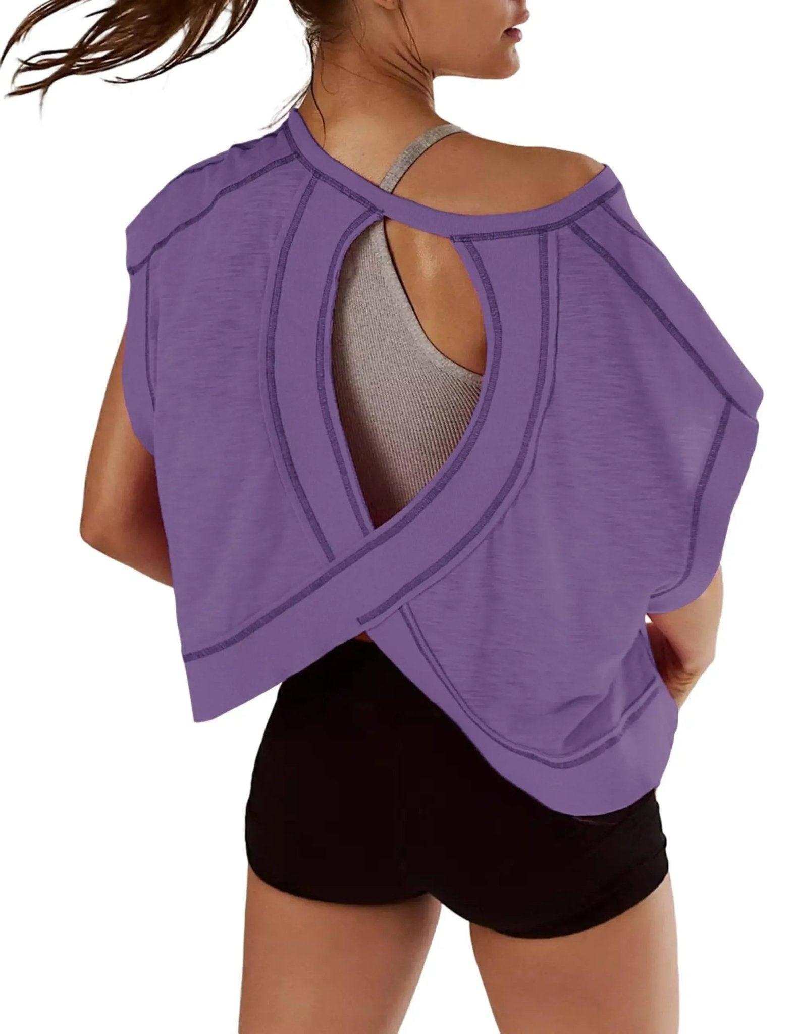 Purple women's workout top with open back design, paired with black shorts for gym or yoga fashion
