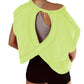 Neon green open-back workout top with crisscross design, paired with black shorts for women's fitness fashion