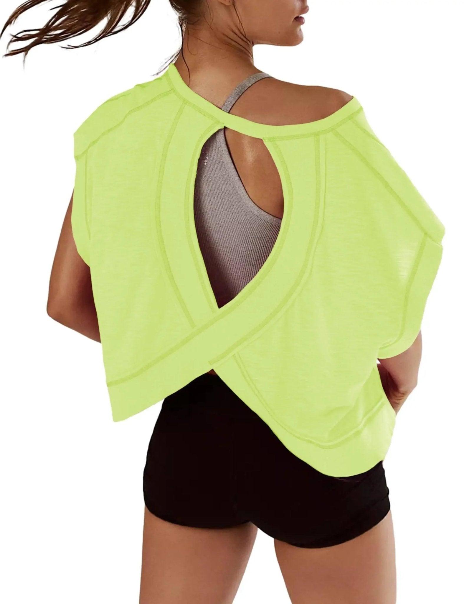 Neon green open-back workout top with crisscross design, paired with black shorts for women's fitness fashion