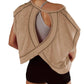 Women's beige open-back workout top with crisscross design, paired with black shorts for gym fashion