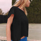 Woman in black cropped tee and blue shorts on tennis court, stylish athleisure fashion