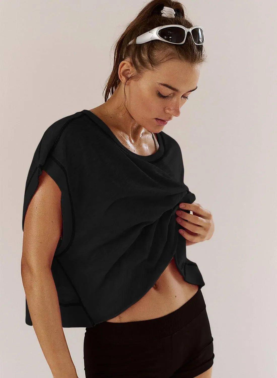 Woman in black workout top and shorts, wearing white sunglasses, post-exercise look