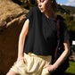 Woman in black sleeveless top and yellow shorts, outdoor fashion look