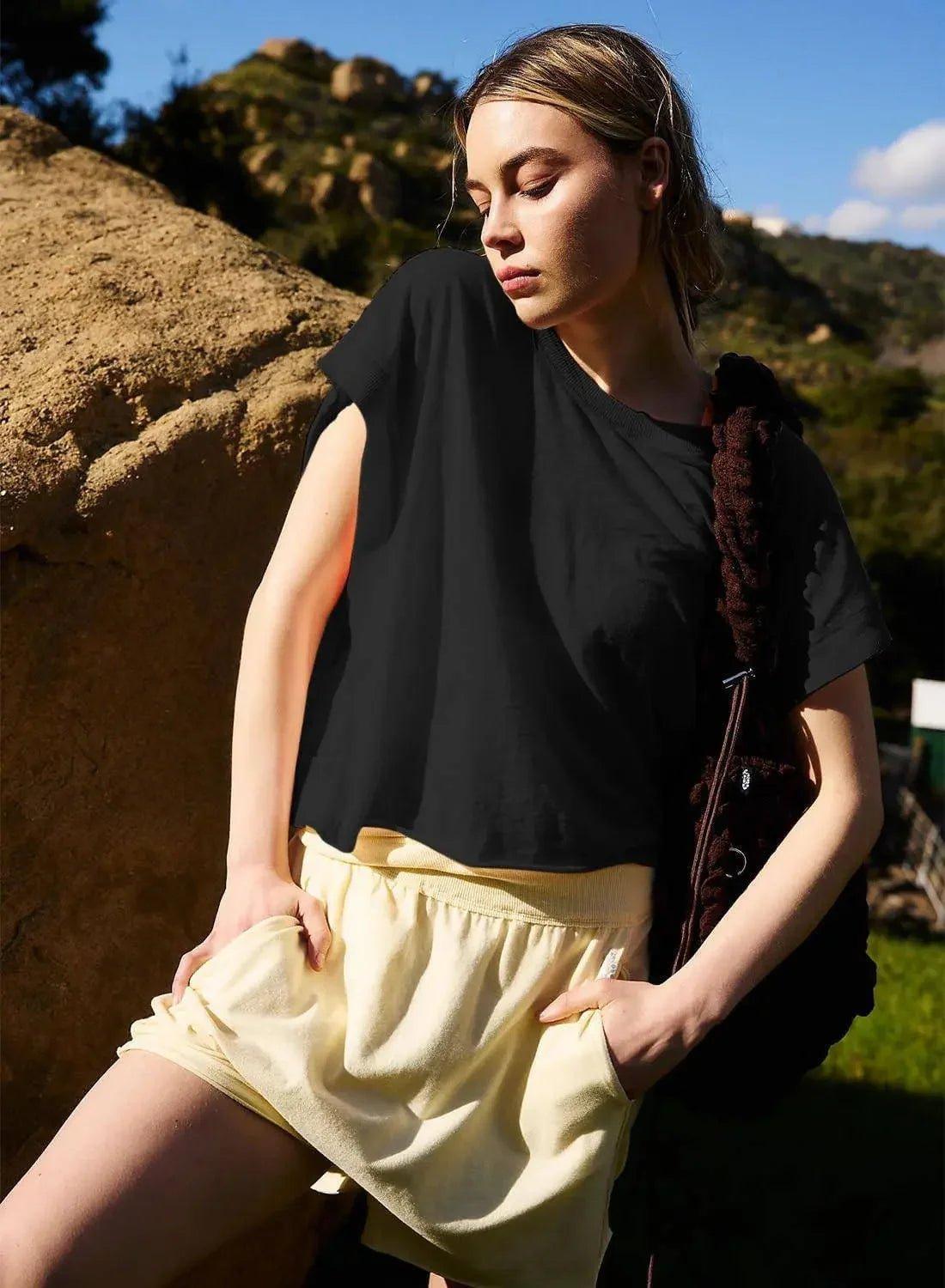 Woman in black sleeveless top and yellow shorts, outdoor fashion look