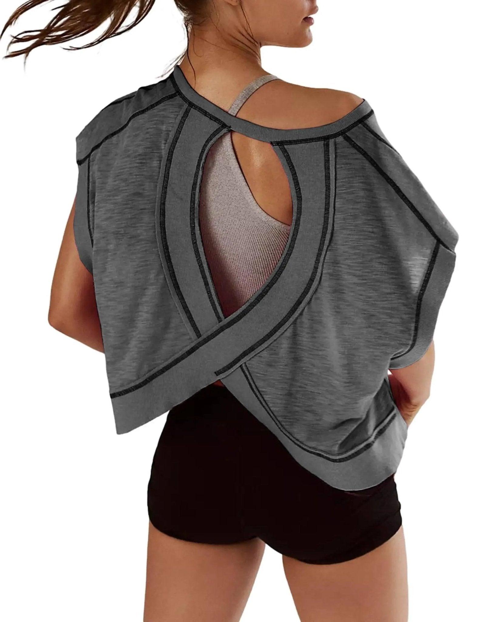 Gray open-back women's workout top with crisscross straps and black trim, paired with black shorts
