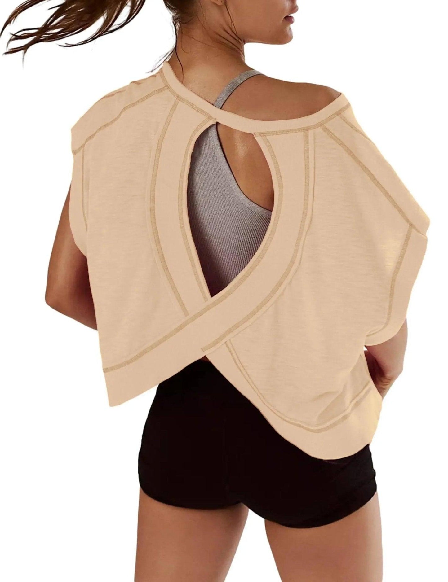 Beige open-back workout top with crisscross design, paired with black shorts for women's fashion