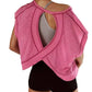 Pink women's workout top with open back design, paired with black shorts for gym or yoga