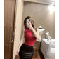 Woman in red sleeveless top and black leather mini skirt, taking mirror selfie in stylish room