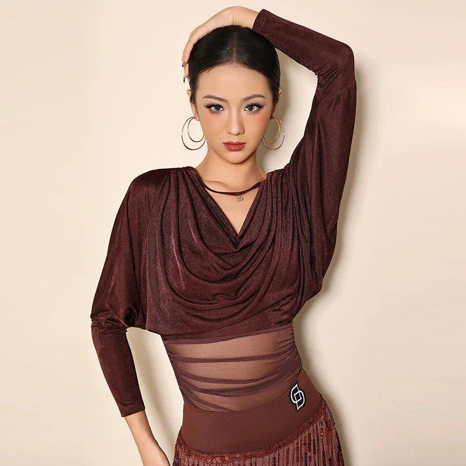 Woman in elegant burgundy long-sleeve dance top with sheer panel and fringe skirt, stylish fashion wear