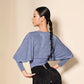 Woman in blue velvet top with wide sleeves and black sequin skirt, elegant fashion look