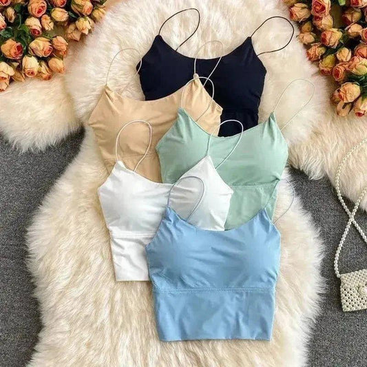 Women's fashion camisoles in black, beige, mint, white, and blue on fluffy rug with roses
