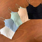 Women's pastel and black camisole tops in soft colors, perfect for layering or casual wear.