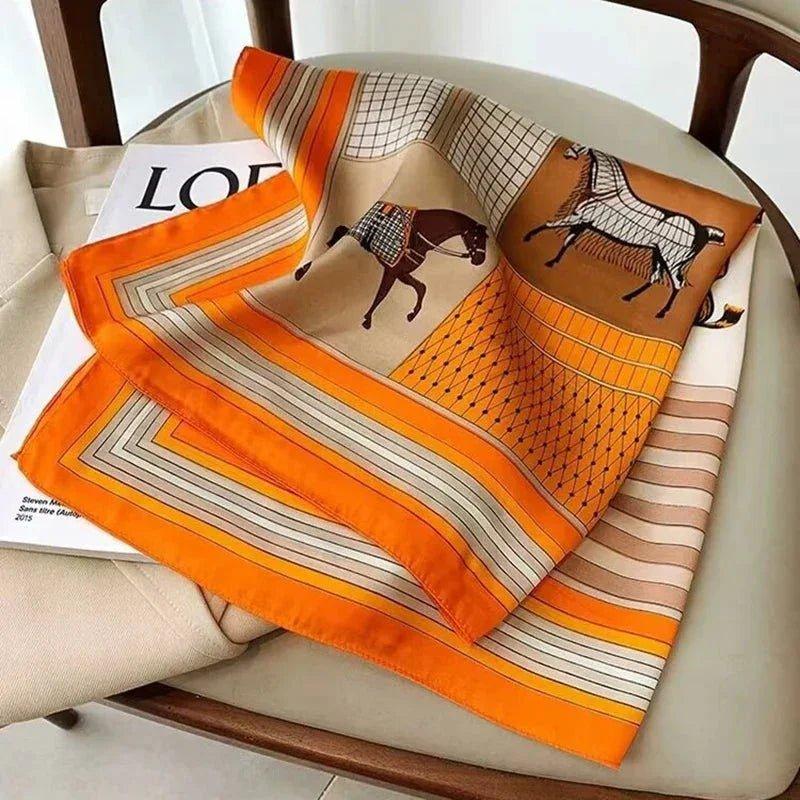 Orange horse print silk scarf for women, stylish fashion accessory on chair with magazine