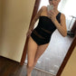 Woman taking mirror selfie in black mesh-cut one-piece swimsuit, stylish beachwear fashion