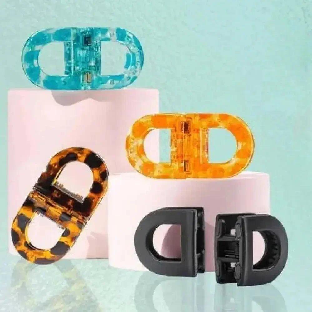 Trendy oval hair clips in tortoise, black, blue, and orange for women's fashion styling