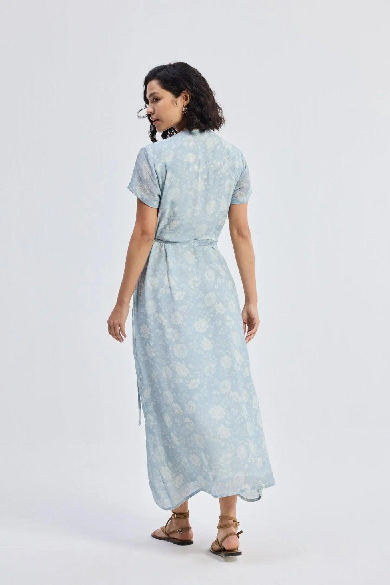 Woman in light blue floral midi dress with short sleeves and tie waist, back view
