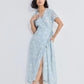 Woman in light blue floral wrap dress with slit, paired with strappy sandals, for summer fashion