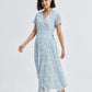 Woman in light blue floral wrap dress with short sleeves and sandals, stylish summer fashion