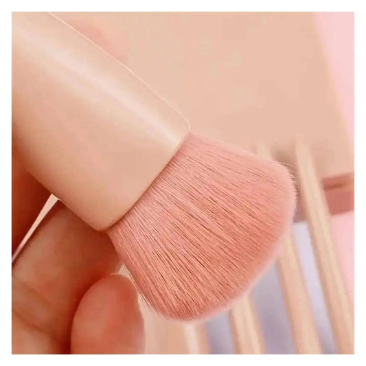 Soft pink makeup brush with smooth handle, perfect for women's beauty and fashion routines