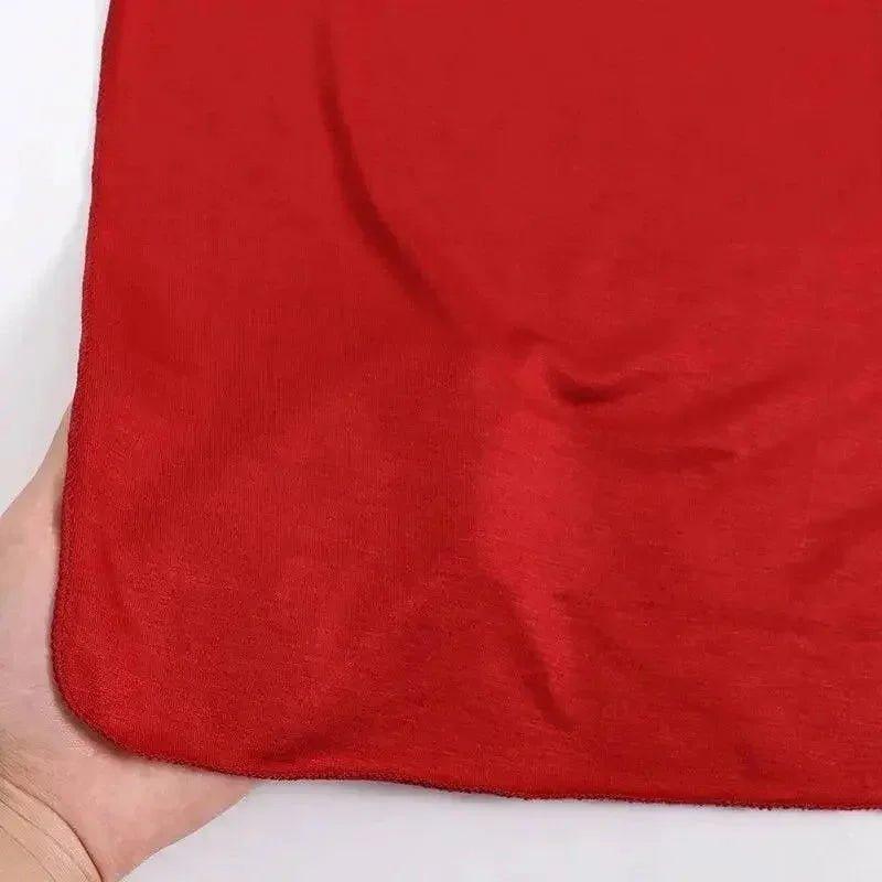 Red fabric swatch held in hand, showcasing texture and vibrant color for fashion design