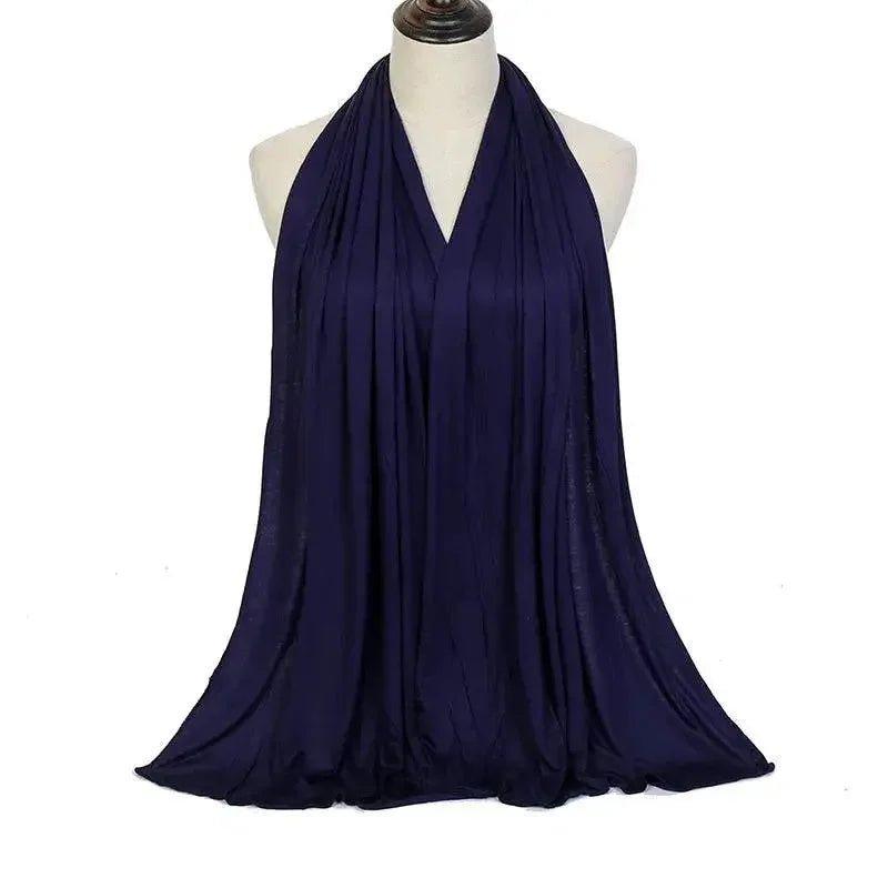 Navy blue women's halter neck dress with flowing fabric, elegant fashion style