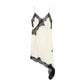 Elegant white lace-trimmed slip dress with black floral detailing, perfect for women's fashion