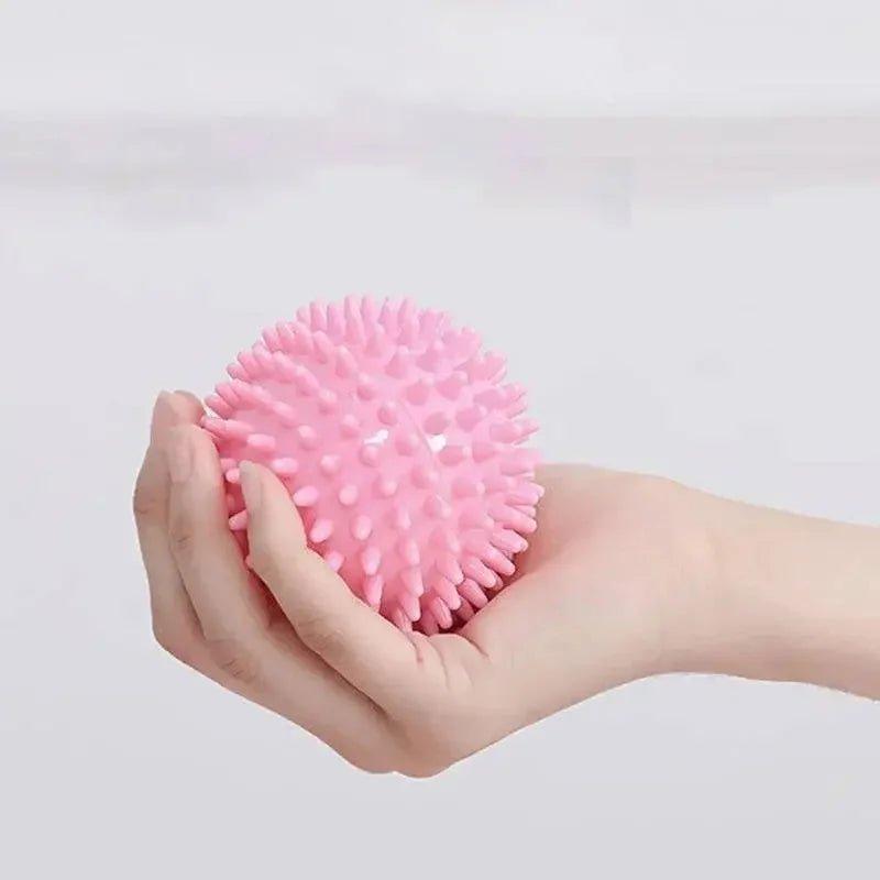 Pink spiky massage ball held in hand for muscle relief and self-care
