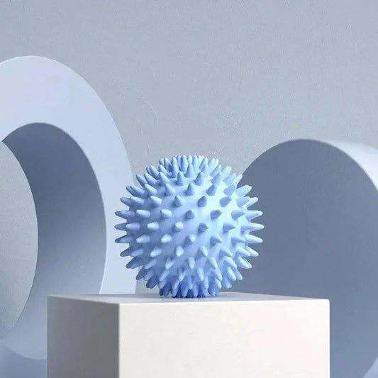 Blue spiky massage ball on white pedestal for muscle relief and relaxation