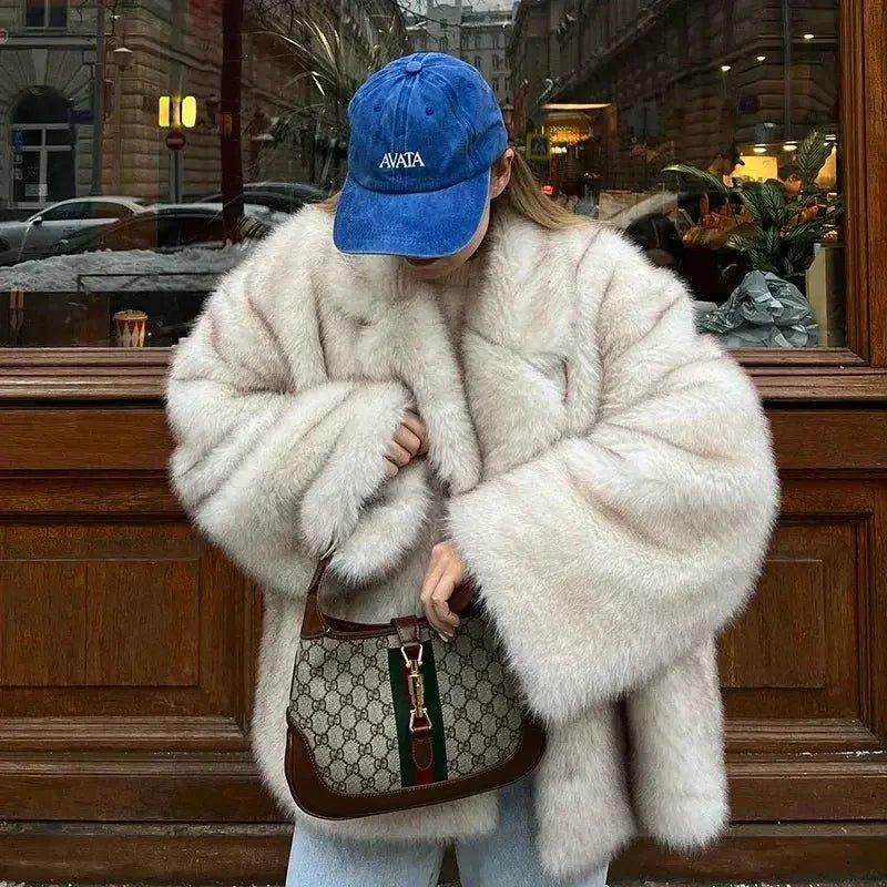 Woman in cozy white faux fur coat, blue AVATA cap, and designer handbag, street fashion style