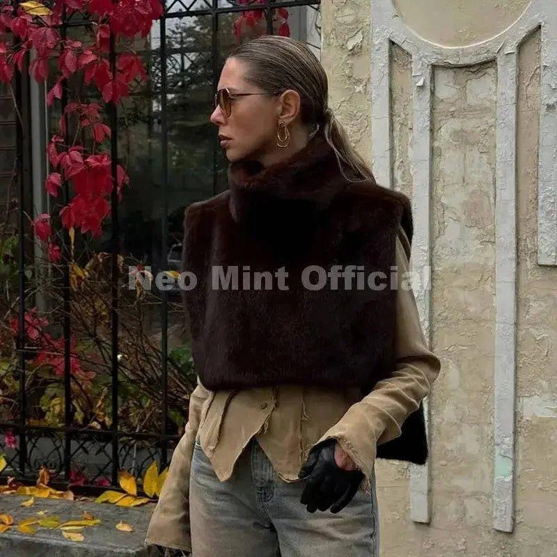 Woman wearing chic brown faux fur vest, sunglasses, and gloves for autumn fashion