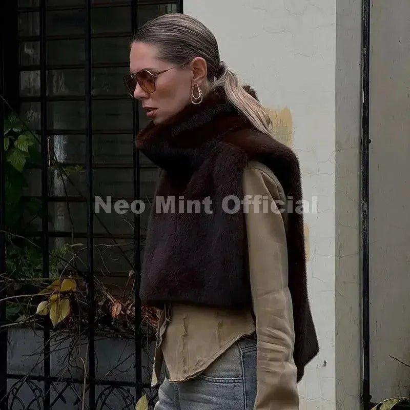 Woman wearing stylish brown faux fur vest, sunglasses, and hoop earrings for chic fall fashion
