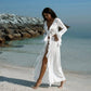 Woman in white ruffled beach cover-up dress by ocean, stylish summer fashion